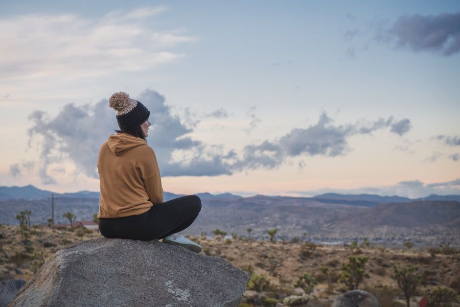 Woman sitting on top of rock at Joshua Tree National Park