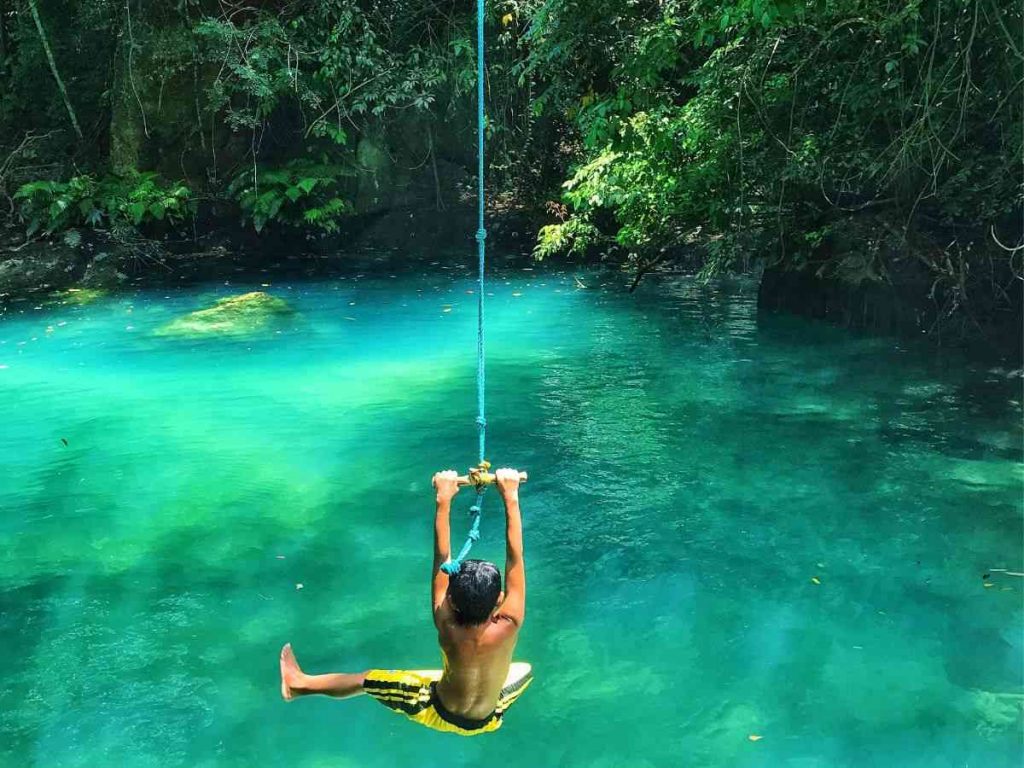 boy swinging into springs example of krause springs in texas